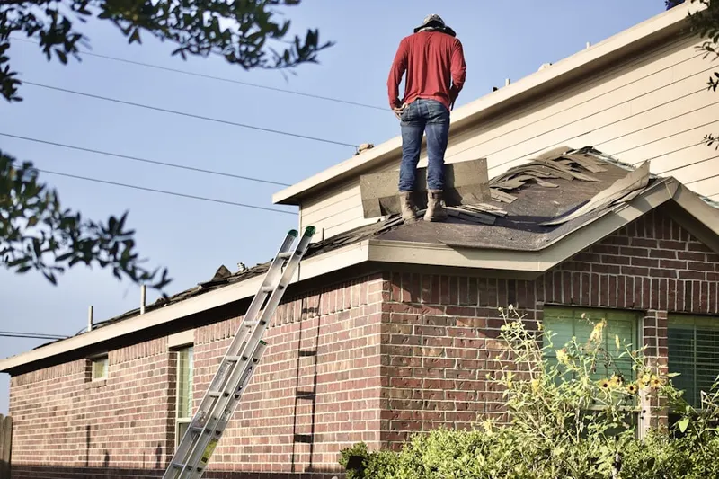 Professional roofer working on a residential roof in Hillmeade